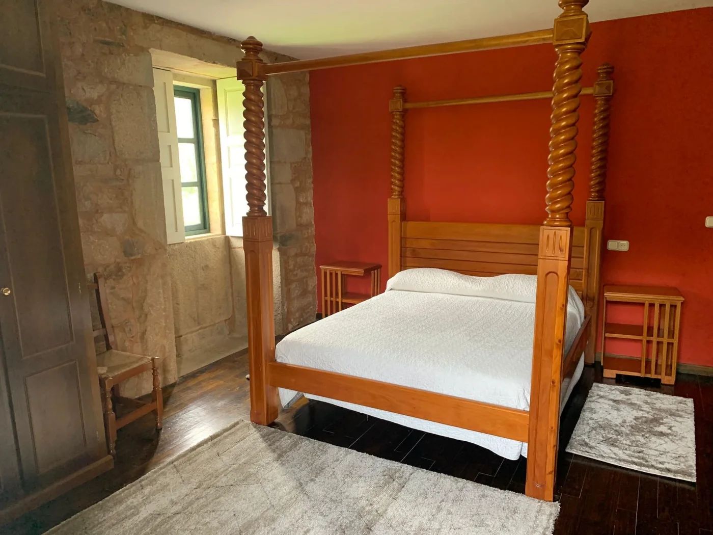 Habitación con cama de dosel de madera