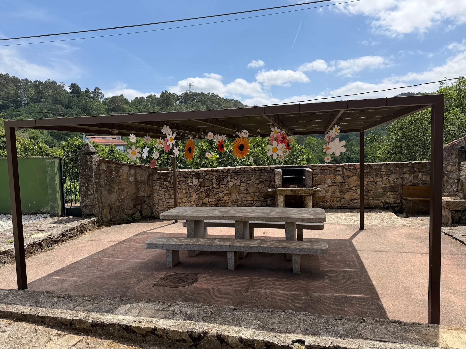 Barbacoa y mesa de piedra bajo la pérgola