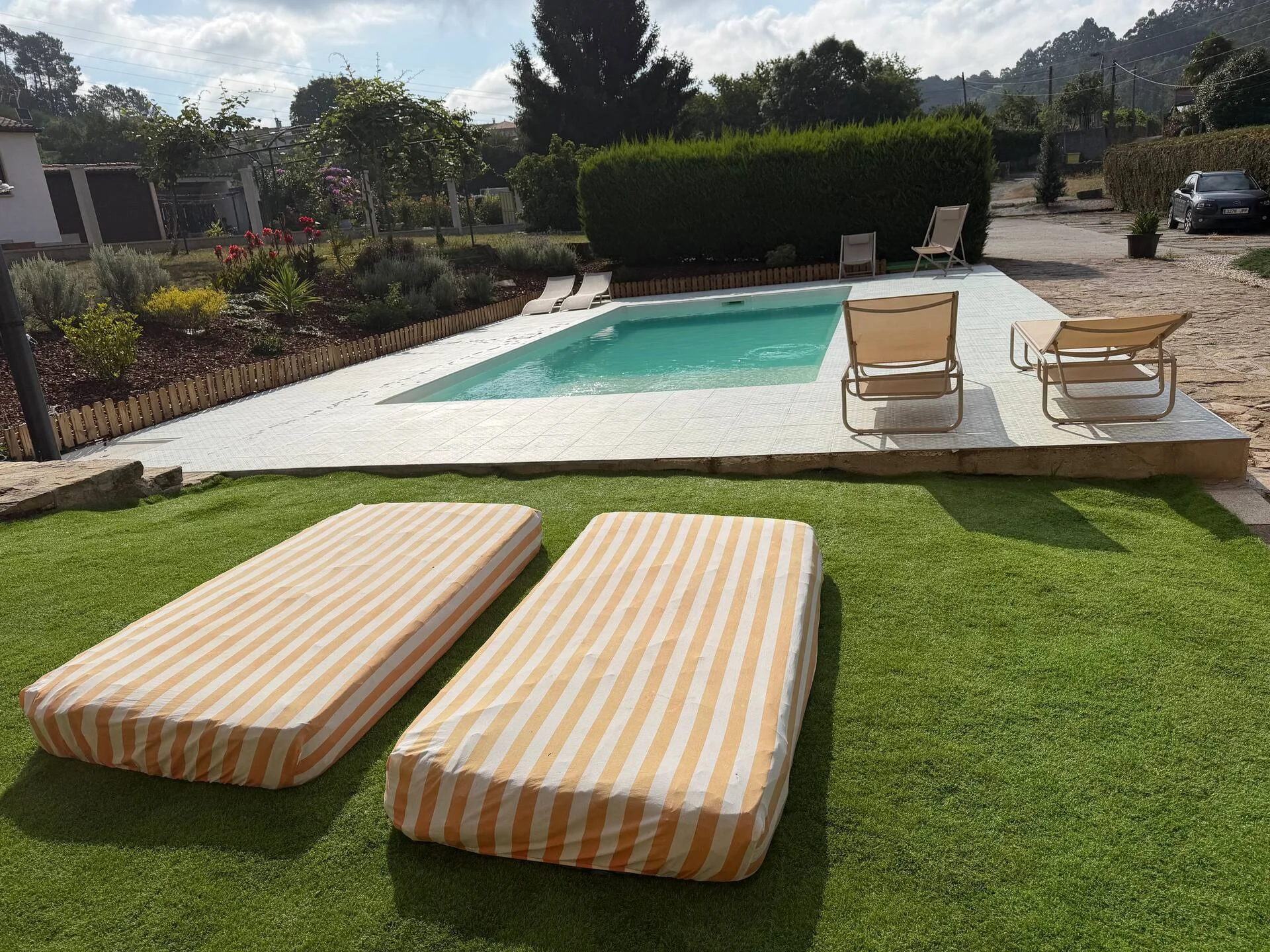 Piscina con tumbonas y césped junto a la casa de piedra